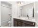 A modern bathroom features double sinks, sleek cabinets, and a shower-tub combo at 8893 Springsong Ln, Littleton, CO 80125