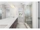Bathroom featuring a double vanity, quartz counters, glass enclosed shower with a tiled floor at 8893 Springsong Ln, Littleton, CO 80125