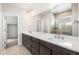 Bathroom featuring a double vanity with a quartz countertop, with a glass enclosed shower at 8893 Springsong Ln, Littleton, CO 80125