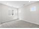 An empty bedroom with neutral carpet, multiple windows, and ample natural light at 8893 Springsong Ln, Littleton, CO 80125