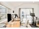 Bright home office featuring two desks, modern decor, and sliding glass doors to a private balcony at 3435 Lawrence St, Denver, CO 80205