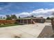 Spacious backyard featuring a patio, garden, driveway, and a detached garage at 1785 S Zuni St, Denver, CO 80223