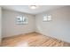 Bright bedroom features gleaming hardwood floors, two windows, and neutral paint at 1785 S Zuni St, Denver, CO 80223