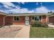 Charming brick home with a well-manicured lawn and lush greenery in the front yard at 1785 S Zuni St, Denver, CO 80223