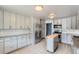 Modern kitchen featuring stainless steel appliances, granite countertops, grey cabinets, and a kitchen island at 1785 S Zuni St, Denver, CO 80223