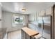 Bright kitchen with an island, stainless steel refrigerator, light grey cabinets, and a view from the window at 1785 S Zuni St, Denver, CO 80223