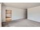 Open living room showing neutral carpet, grey walls, and an entryway to the kitchen at 1785 S Zuni St, Denver, CO 80223