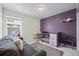 Welcoming Bedroom with a crib, couch, changing table and purple accent wall at 24784 E Tennessee Pl, Aurora, CO 80018