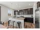 This kitchen features dark cabinets, granite countertops, a backsplash, stainless steel appliances and three bar stools at 24784 E Tennessee Pl, Aurora, CO 80018