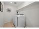 Clean laundry room with white washer, dryer, shelf and tile flooring at 24784 E Tennessee Pl, Aurora, CO 80018