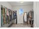 Bright walk-in closet with organized hanging racks and a mirror, providing ample storage space at 24784 E Tennessee Pl, Aurora, CO 80018