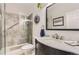 Charming bathroom featuring a modern vanity, a glass-enclosed shower and decorative fixtures at 2700 W Greens Pl, Littleton, CO 80123
