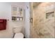 Beautiful bathroom with modern tiled shower featuring a built-in niche and glass doors at 2700 W Greens Pl, Littleton, CO 80123