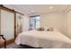 Bright bedroom featuring a large bed, soft carpet and modern barn door to the bathroom at 2700 W Greens Pl, Littleton, CO 80123