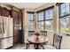 Bright breakfast nook with a wood table set by three windows offering natural light and custom wood cabinets at 2700 W Greens Pl, Littleton, CO 80123