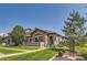 Beautiful home featuring a stone facade, landscaped lawn, and a cozy front porch for relaxing and enjoying the outdoors at 2700 W Greens Pl, Littleton, CO 80123
