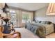 Bright main bedroom featuring a large window, balcony access and soft carpet at 2700 W Greens Pl, Littleton, CO 80123
