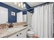 Cozy bathroom featuring granite countertop, shower-tub combo and blue walls at 3928 Miners Candle Dr, Castle Rock, CO 80109