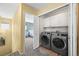 Upper floor hall view into laundry room with modern washer and dryer at 3928 Miners Candle Dr, Castle Rock, CO 80109