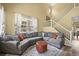 Comfortable living room with a large sectional sofa, ottoman, and staircase at 3928 Miners Candle Dr, Castle Rock, CO 80109