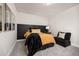 Cozy bedroom with paneled headboard, unique artwork, and a comfortable black accent chair at 12846 Palisade St, Mead, CO 80504