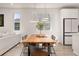 Dining area with modern lighting, a wooden table, seating for six, and abundant natural light at 12846 Palisade St, Mead, CO 80504