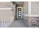 Close-up of the front door showcasing stone accents and a modern glass insert design that exudes curb appeal at 12846 Palisade St, Mead, CO 80504