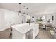 Open kitchen with a large island, white cabinets, stainless appliances, and seamless flow into the living spaces at 12846 Palisade St, Mead, CO 80504