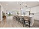 Open-concept kitchen with white cabinets, quartz countertops, island with seating, and stainless steel appliances at 12846 Palisade St, Mead, CO 80504