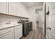 Well-appointed laundry room with ample storage, modern washer and dryer, and a convenient sink at 12846 Palisade St, Mead, CO 80504