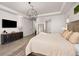 Spacious main bedroom with wood floors, tray ceilings, an orb chandelier, and a large television at 12846 Palisade St, Mead, CO 80504