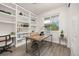 Well-lit home office with built-in bookshelves and a large window, perfect for a productive workspace at 12846 Palisade St, Mead, CO 80504