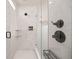 Modern walk-in shower with a glass door, white marbled walls, and matte black hardware at 12846 Palisade St, Mead, CO 80504
