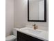 Modern powder bath with a framed mirror, dark cabinet and quartz counter at 8015 Parnassus Pl, Castle Rock, CO 80108