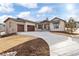 Inviting home exterior with stone accents, covered entryway, three car garage, and curved driveway at 8015 Parnassus Pl, Castle Rock, CO 80108