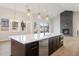 Modern kitchen island with stainless steel dishwasher overlooking a living room with stone fireplace at 8015 Parnassus Pl, Castle Rock, CO 80108