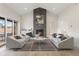 Bright living room with stone fireplace, vaulted ceiling, and sliding glass doors to the outside at 8015 Parnassus Pl, Castle Rock, CO 80108