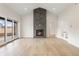 Light-filled living room with a stone fireplace, vaulted ceiling, and access to the backyard at 8015 Parnassus Pl, Castle Rock, CO 80108