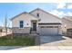 Charming two-story home featuring stone accents, a two-car garage, and manicured landscaping at 8926 S Rome Ct, Aurora, CO 80016