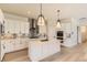 Modern kitchen featuring white cabinetry, a large island, and stylish pendant lighting at 8926 S Rome Ct, Aurora, CO 80016