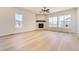 Expansive living room featuring a stone fireplace, large windows, and hardwood flooring at 8926 S Rome Ct, Aurora, CO 80016