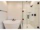 Bright bathroom featuring a tub and shower with white marble tile at 8926 S Rome Ct, Aurora, CO 80016