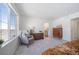 Bright bedroom featuring a large window, cozy chair, and neutral decor with attached bathroom at 22023 E 38Th Pl, Aurora, CO 80019