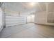 Spacious two-car garage with concrete floor and white door at 22023 E 38Th Pl, Aurora, CO 80019