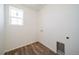 Bright laundry room features wood-look floors, and window for natural light at 22023 E 38Th Pl, Aurora, CO 80019