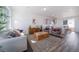 Bright living room with contemporary furnishings, stylish rug, and a view into the modern kitchen at 22023 E 38Th Pl, Aurora, CO 80019