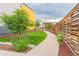 Well-maintained backyard with walkway, garden beds, and privacy fence at 6892 Juniper Ct, Arvada, CO 80007