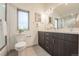 Modern bathroom with a double vanity, gray cabinets, and a walk-in shower at 6892 Juniper Ct, Arvada, CO 80007
