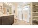 Elegant bathroom with a glass shower, vanity, and storage shelves at 6892 Juniper Ct, Arvada, CO 80007