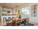 Open-concept living space with a dining area connected to the modern kitchen and a large window view at 6892 Juniper Ct, Arvada, CO 80007